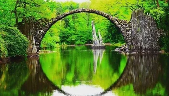 Rakotzbrücke, Jerman. Kalau pakai AI mungkin prompt-nya bikin nuansa alam yang terlihat seperti cermin di tengahnya. Foto: ir_blues via Bored Panda
