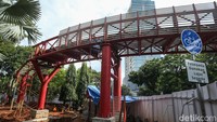 Skybridge merah menjadi elemen visual utama taman, sekaligus jalur penghubung pejalan kaki antar ruang hijau di kawasan tersebut.  