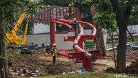Sejumlah pekerja menyelesaikan konstruksi jembatan skybridge berwarna merah yang akan menghubungkan antar taman dan melintasi Jalan Barito 1.  