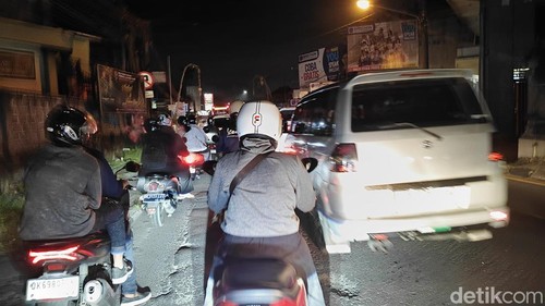 Pengendara motor menerobos antrean mobil yang terjebak macet di jalur Denpasar-Gilimanuk, Kabupaten Badung, Jumat malam. (Agus Eka/detikBali)