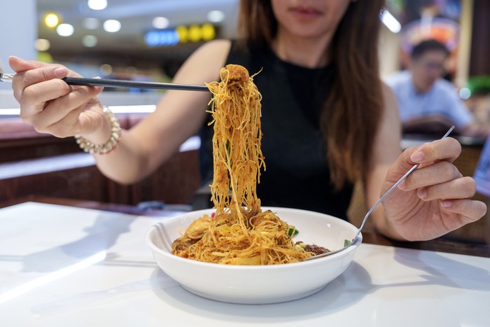 Ilustrasi wanita makan bihun