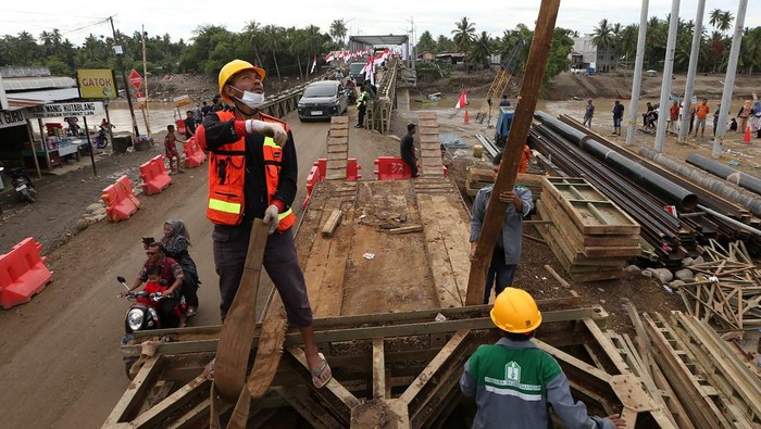 Warga dan kendaraan melewati jembatan darurat bailey Krueng Tingkeum yang baru selesai dibangun di Kuta Blang, Bireuen, Aceh, Sabtu (27/12/2025). Pemerintah bersama TNI/Polri telah menyelesaikan jembatan bailey Krueng Tingkeum, Kuta Blang  pascabencana banjir bandang yang merusak jembatan permanen akhir November lalu sepanjang 66 meter dengan kapasitas beban maksimal 30 ton sebagai upaya menghubungkan jalan negara Banda Aceh-Medan serta memperlancar distribusi logistik antar daerah. ANTARA FOTO/Irwansyah Putra/sgd