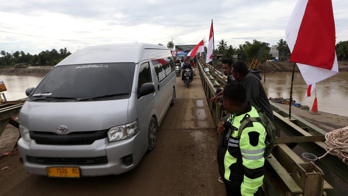 Warga dan kendaraan melewati jembatan darurat bailey Krueng Tingkeum yang baru selesai dibangun di Kuta Blang, Bireuen, Aceh, Sabtu (27/12/2025). Pemerintah bersama TNI/Polri telah menyelesaikan jembatan bailey Krueng Tingkeum, Kuta Blang  pascabencana banjir bandang yang merusak jembatan permanen akhir November lalu sepanjang 66 meter dengan kapasitas beban maksimal 30 ton sebagai upaya menghubungkan jalan negara Banda Aceh-Medan serta memperlancar distribusi logistik antar daerah. ANTARA FOTO/Irwansyah Putra/sgd
