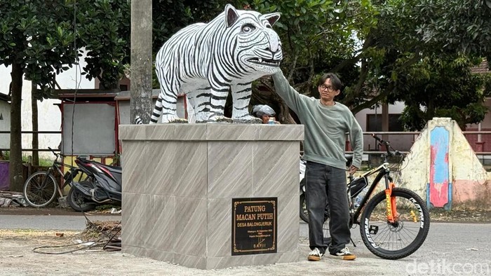 Sejumlah warga berfoto dengan patung Macan Putih di Kediri yang viral karena bentuknya lucu.
