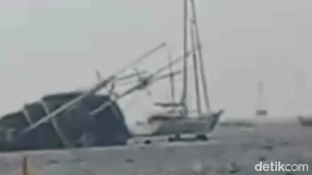 Tangkapan layar video detik-detik kapal pinisi tenggelam di Pelabuhan Serangan, Denpasar, Bali, Sabtu (27/12/2025). Tangkapan layar video detik-detik kapal pinisi tenggelam di Pelabuhan Serangan, Denpasar, Bali, Sabtu (27/12/2025).