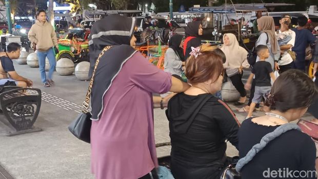 Tukang pijat keliling, Bu Tina, saat memijat pelanggan di kawasan Malioboro, Jogja, Rabu (24/12/2025).