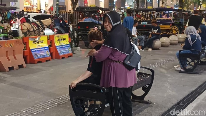 Tukang pijat keliling, Bu Tina, saat memijat pelanggan di kawasan Malioboro, Jogja, Rabu (24/12/2025).