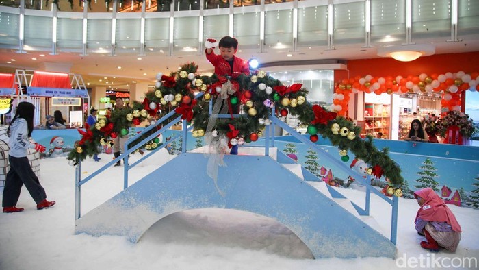 Sejumlah pegunjung bermain salju buatan di wahana Magical Chirstmas Snowy Celebration di Mal Artha Gading, Jakarta Utara, Sabtu (27/12/2025). Suasana pusat perbelanjaan berubah menjadi layaknya negeri musim dingin dengan hamparan salju putih, dekorasi pohon Natal berukuran besar, serta ornamen khas akhir tahun yang menghiasi hampir seluruh area wahana.