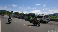 Kantong parkir penuh dan membeludak ke jalan raya.