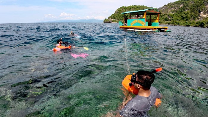 Sejumlah wisatawan menyelam bebas atau free dive di gugusan terumbu karang objek wisata Oluhuta Paradise di Kabupaten Bone Bolango, Gorontalo, Minggu (28/12/2025). Kunjungan ke objek wisata minat khusus tersebut meningkat dari rata-rata 19 orang/hari menjadi 130 orang/hari berkenaan dengan libur Natal 2025 dan Tahun Baru 2026. ANTARA FOTO/Adiwinata Solihin