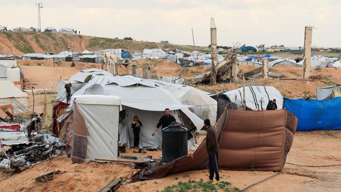 Warga Palestina yang mengungsi menghadapi tantangan baru di tengah musim dingin yang menyelimuti Jalur Gaza. Di Khan Younis, Gaza selatan, pengungsi terpaksa berlindung di kamp tenda untuk melindungi diri dari suhu yang rendah, Minggu (28/12/2025). REUTERS/Haseeb Alwazeer