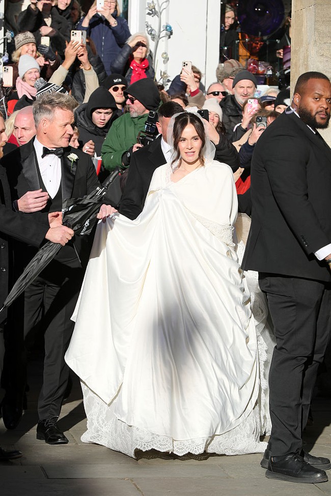Holly Ramsay, putri chef Gordon Ramsay, baru saja dipersunting atlet renang, Adam Peaty. Dalam foto yang beredar ketika hari pernikahan, Holly keluar gereja mengenakan jubah sehingga gaunnya tidak terlihat. Foto: Getty Images/Ben Birchall