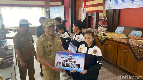 Bupati Karangasem I Gusti Putu Parwata menyerahkan bonus untuk atlet Porprov 2025 di Aula Disdikpora Karangasem, Senin (29/12/2025).