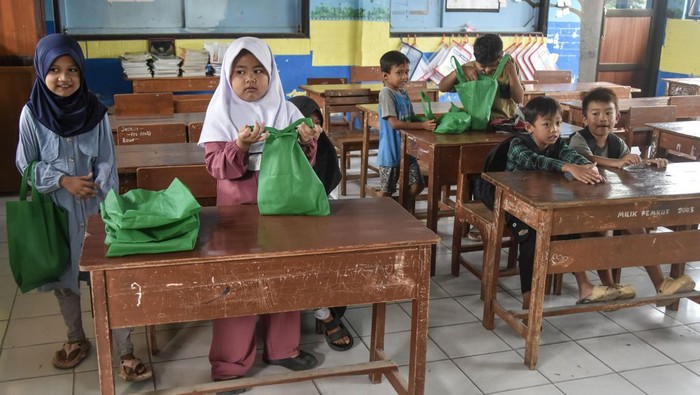 Sejumlah siswa menerima Makan Bergizi Gratis (MBG) di SDN 1 Gunung Lipung, Kota Tasikmalaya, Jawa Barat, Senin (29/12/2025). Satuan Pelayanan Pemenuhan Gizi (SPPG) tetap menyalurkan bantuan MBG selama tiga hari berupa susu, buah, roti, biskuit, dan keju pada masa libur sekolah guna memastikan kebutuhan gizi anak tetap terpenuhi. ANTARA FOTO/Adeng Bustomi/YU