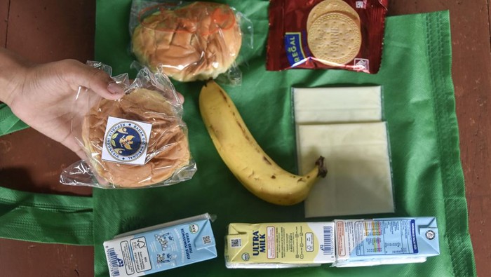 Siswa memperlihatkan menu Makan Bergizi Gratis (MBG) di SDN 1 Gunung Lipung, Kota Tasikmalaya, Jawa Barat, Senin (29/12/2025). Satuan Pelayanan Pemenuhan Gizi (SPPG) tetap menyalurkan bantuan MBG selama tiga hari berupa susu, buah, roti, biskuit, dan keju pada masa libur sekolah guna memastikan kebutuhan gizi anak tetap terpenuhi. ANTARA FOTO/Adeng Bustomi/YU