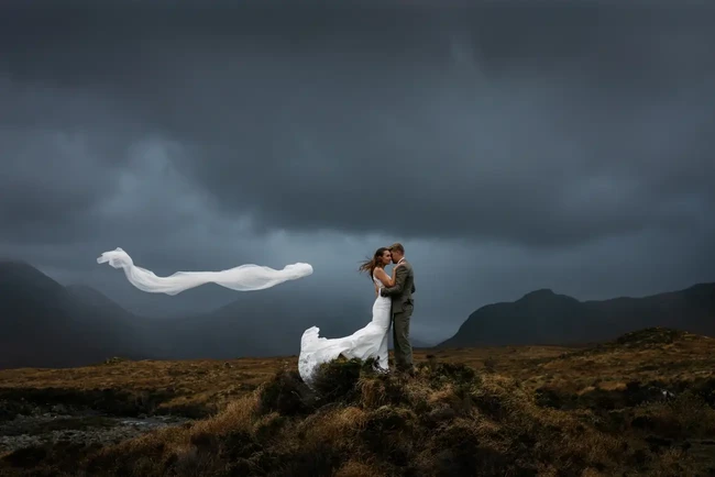 Inilah juara pertama untuk kategori Couple Portrait dan Emerging Artist. Fotografer Oli Prince menampilkan pengantin pria dan wanita di lereng gunung yang dilanda badai di Pegunungan Cuillin, Skotlandia. Foto: Dok. iwpoty.com