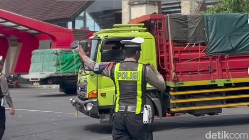 Petugas menindak truk yang masih melintas saat penerapan larangan melintas saag libur Nataru di Jembrana, Senin (29/12/2025).