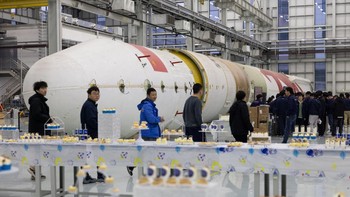 Karyawan berkumpul selama acara di samping badan roket uji untuk program Zhuque-2. LandSpace, dan fokus tunggalnya untuk memberikan China pilihan peluncuran berbiaya rendah sendiri yang mirip dengan Falcon 9 milik SpaceX, akan memainkan peran kunci dalam rencana Beijing untuk membangun konstelasi puluhan ribu satelit dalam beberapa dekade mendatang. Foto: REUTERS/Maxim Shemetov