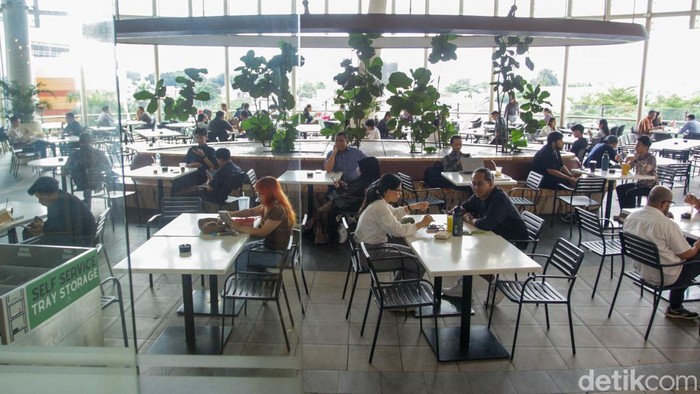 Pengunjung bekerja menggunakan komputer jinjing saat penerapan kebijakan Work From Anywhere di Pondok Indah Mall, Jakarta, Senin (29/12/2025).