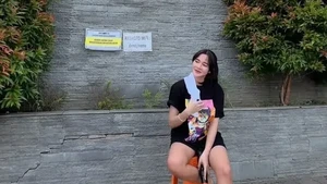 Duduk di kursi plastik, Bella Bonita jalani peran tukang parkir ala warga lokal. Foto: Instagram Bella Bonita
