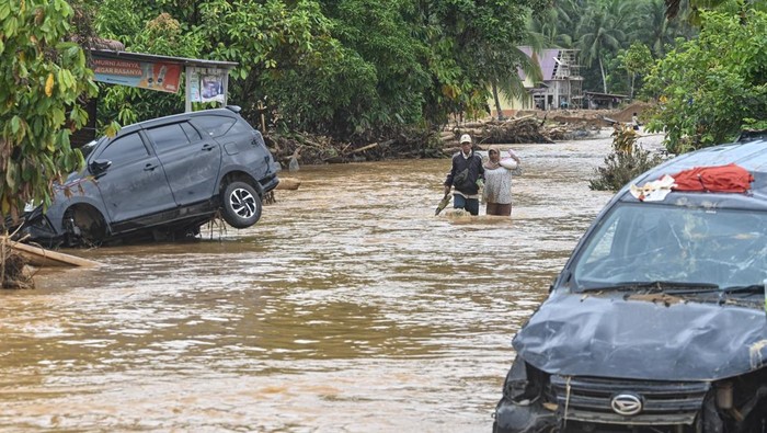 Desember 2025: Banjir Bandang dan Longsor Terjang Sumatera Warga melintasi banjir yang menggenangi permukiman penduduk di Kelurahan Tukka, Kecamatan Tukka,Tapanuli Tengah, Sumatera Utara, Minggu (7/12/2025). Banjir serta kondisi jalan yang dipenuhi endapan tanah mempersulit proses pengiriman bantuan logistik ke wilayah tersebut. ANTARA FOTO/Muhammad Adimaja/nz