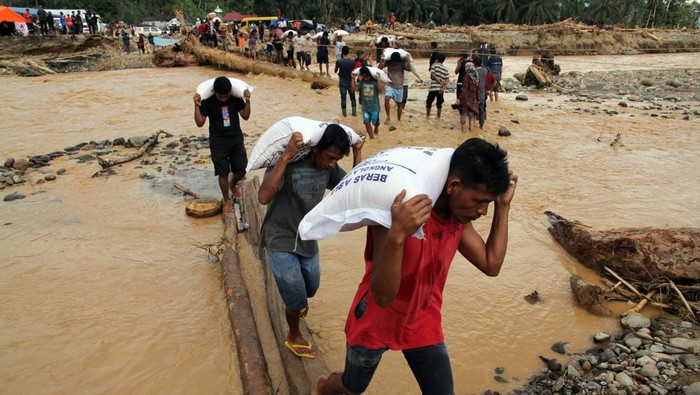 Desember 2025: Banjir Bandang dan Longsor Terjang Sumatera Petugas memikul beras untuk dibagikan kepada korban banjir bandang di Desa Aek Garoga, Kecamatan Batang Toru, Tapanuli Selatan, Sumatera Utara, Senin (1/12/2025). Pemerintah dan sejumlah perusahaan swasta mulai menyalurkan bantuan logistik untuk korban banjir bandang di Tapanuli Selatan dan Tapanuli Tengah.ANTARA FOTO/Yudi Manar/YU