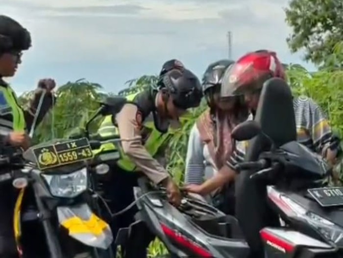 Polisi membantu wisatawan yang kehabisan bensin di Kudus.