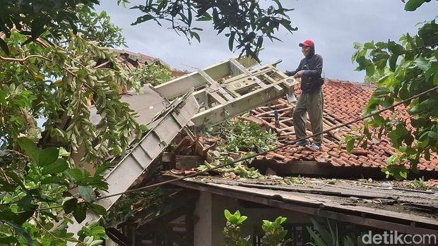 Polisi-TNI mengevakuasi bangkai potongan pesawat yang menimpa rumah warga di Kemang, Bogor. (Sholihin/detikcom)