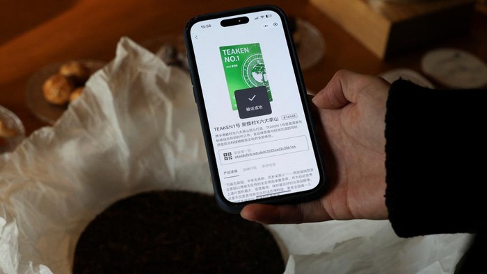 Eric Ma, founder and CEO of Teaken, scans a tea cake with the smartphone application at Bei Teahouse in Shanghai, China, December 15, 2025. REUTERS/Go Nakamura