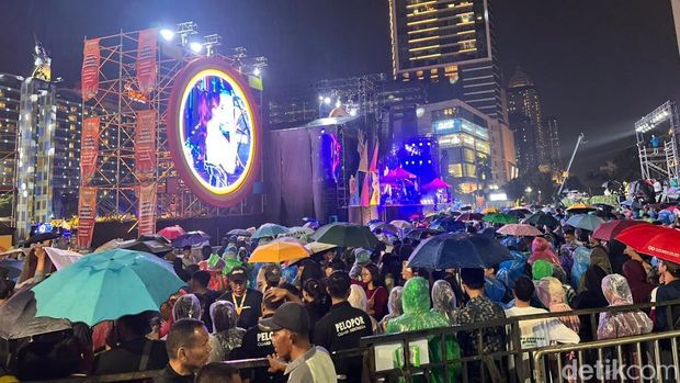 Jakarta diguyur hujan malam ini. Warga tetap ramai menanti malam pergantian tahun di Bundaran Hotel Indonesia (HI), Jakarta Pusat. (Adhfar/detikcom).