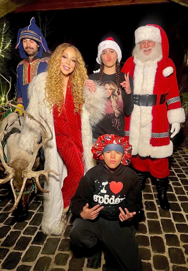 Saat malam Natal, Mariah mengenakan piyama merah yang senada dengan cosplayer yang mengenakan kostum Sinterklas. Meskipun memakai piyama, dia tetap memberi sentuhan festive dengann mantel bulu panjang. Foto: Instagram/@mariahcarey