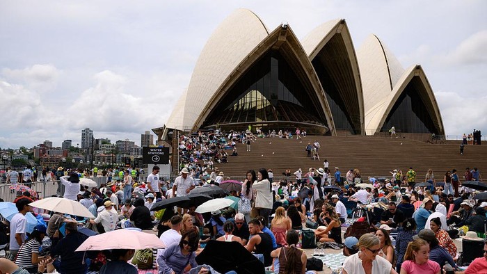 SYDNEY, AUSTRALIA - DECEMBER 31: People wearing I love Sydney shirts pose for a photo while gathering at the Sydney Opera House in anticipation of the annual New Years Eve fireworks display on December 31, 2025 in Sydney, Australia. Thousands will