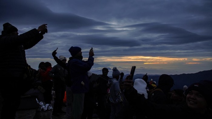 Wisatawan mengabadikan gambar matahari terbit di Penanjakan Satu Bromo, Kabupaten Pasuruan, Jawa Timur, Kamis (1/1/2026). Kawasan Taman Nasional Bromo Tengger Semeru (TNBTS) dikunjungi wisatawan yang sengaja datang untuk menyaksikan matahari terbit pertama di tahun 2026. ANTARA FOTO/Irfan Sumanjaya