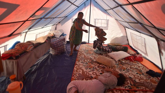 Seorang warga penyintas bencana membuka tenda bantuan di Talao Mundam, Nagari Katapiang, Padang Pariaman, Sumatera Barat, Kamis (1/1/2026). Sebulan pascabencana banjir bandang, sejumlah warga yang kehilangan rumah mereka akibat banjir bandang masih tinggal di dalam tenda bantuan karena menunggu selesainya pembangunan hunian sementara.  ANTARA FOTO/Iggoy el Fitra/bar
