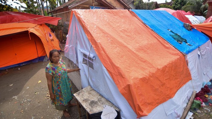 Seorang warga penyintas bencana membuka tenda bantuan di Talao Mundam, Nagari Katapiang, Padang Pariaman, Sumatera Barat, Kamis (1/1/2026). Sebulan pascabencana banjir bandang, sejumlah warga yang kehilangan rumah mereka akibat banjir bandang masih tinggal di dalam tenda bantuan karena menunggu selesainya pembangunan hunian sementara.  ANTARA FOTO/Iggoy el Fitra/bar