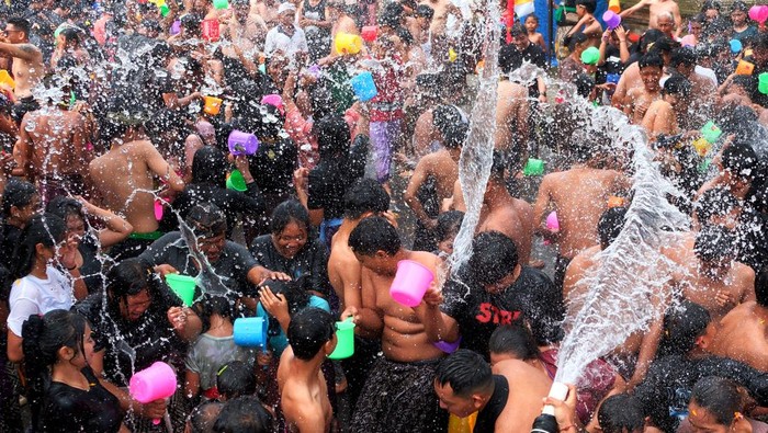 Warga saling menyiram air saat tradisi perang air pada Festival Air Suwat di Desa Suwat, Gianyar, Bali, Kamis (1/1/2026). Tradisi tahunan yang digelar setiap tanggal 1 Januari tersebut mengusung tema mengalir bersama air dengan diikuti ratusan orang sebagai ritual pembersihan diri serta spiritual untuk membangkitkan energi positif sekaligus memperkuat hubungan persaudaraan antar warga dan menjadi daya tarik pariwisata. ANTARA FOTO/Nyoman Hendra Wibowo/bar