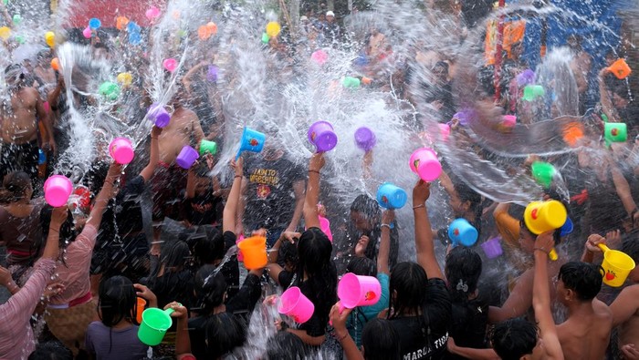 Warga saling menyiram air saat tradisi perang air pada Festival Air Suwat di Desa Suwat, Gianyar, Bali, Kamis (1/1/2026). Tradisi tahunan yang digelar setiap tanggal 1 Januari tersebut mengusung tema mengalir bersama air dengan diikuti ratusan orang sebagai ritual pembersihan diri serta spiritual untuk membangkitkan energi positif sekaligus memperkuat hubungan persaudaraan antar warga dan menjadi daya tarik pariwisata. ANTARA FOTO/Nyoman Hendra Wibowo/bar