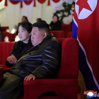 Salah satu momen yang paling mencuri perhatian terjadi saat perayaan Tahun Baru 2026 di Pyongyang. Ketika Kim Jong-un menepuk kursi di sampingnya, Kim Ju-ae menghampiri lalu mencium pipi sang ayah di hadapan para pejabat dan masyarakat. Bagi sejumlah analis, adegan tersebut bukan sekadar bentuk kasih sayang antara ayah dan anak, namun bagian dari rangkaian simbol yang membangun citra Kim Ju-ae sebagai figur penting dalam suksesi kepemimpinan Korea Utara. Foto: via REUTERS/KCNA