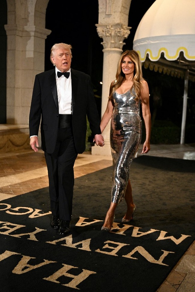 Pergantian tahun selalu identik dengan suasana meriah, dan Melania Trump tahu betul cara menampilkannya lewat gaya busana. First Lady of Unites States (FLOTUS) ini menyambut Tahun Baru dalam sebuah pesta glamor di Mar-a-Lago, Palm Beach, Florida, Rabu (31/12/2025) malam. Foto: AFP/JIM WATSON