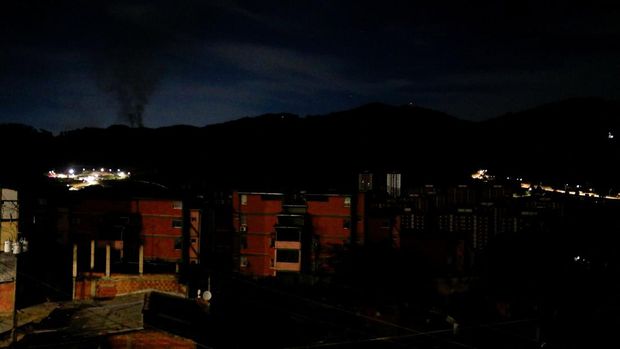 Asap mengepul di dekat Benteng Tiuna selama pemadaman listrik total, menyusul ledakan dan suara keras, di tengah meningkatnya ketegangan antara pemerintahan Presiden AS Donald Trump dan Presiden Venezuela Nicolas Maduro, di Caracas, Venezuela, 3 Januari 2026. REUTERS/Leonardo Fernandez Viloria