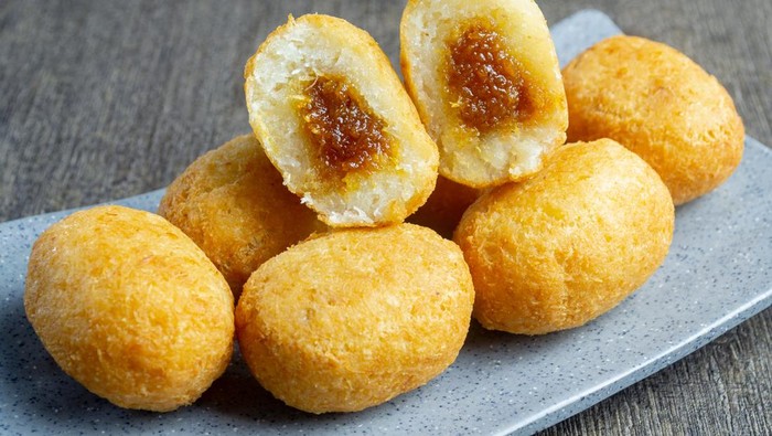 Misro is a typical snack from West Java Indonesia. This snack is made from grated cassava, the inside of which is filled with brown sugar and then fried. served on a plate with a dark table mat