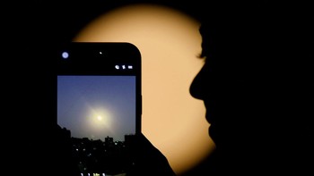 Seorang wanita menggunakan ponsel pintarnya untuk Mengabadikan Bulan Serigala, supermoon pertama tahun 2026, saat menerangi langit malam di Kairo, Mesir. Wolf Moon tahun ini akan menjadi sangat istimewa, karena bertepatan dengan dua peristiwa langit lainnya, memberikan suguhan kosmik langka yang langka. Foto: REUTERS/Mohamed Abd El Ghany