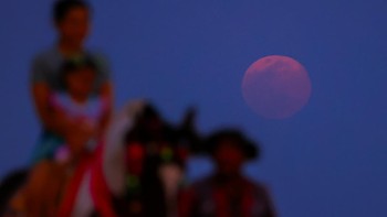 Orang-orang menunggang kuda saat supermoon Serigala, supermoon pertama tahun 2026, terbit di atas laut di Pantai Cha-Am, di provinsi Phetchaburi, Thailand. Foto: REUTERS/Chalinee Thirasupa