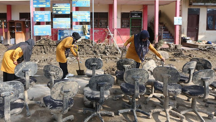 Tenaga pengajar membersihkan pekarangan dan berbagai peralatan sekolah dari lumpur dampak banjir bandang di SD Negeri 3 Percontohan Peusangan, Bireuen, Aceh, Minggu (4/1/2026). Kementerian Pendidikan Dasar dan Menengah (Kemendikdasmen) memastikan sebanyak 3.508 unit dari 4.149 satuan pendidikan yang terdampak bencana hidrometeorologi di Provinsi Sumatra Utara, Sumatra Barat dan Aceh siap melaksanakan pembelajaran semester genap pada 5 Januari 2026. ANTARA FOTO/Irwansyah Putra/rwa.