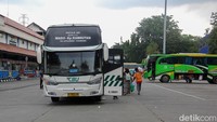 Bus antarkota antarprovinsi (AKAP) datang dan berangkat silih berganti, dengan penumpang memenuhi area ruang tunggu terminal. 