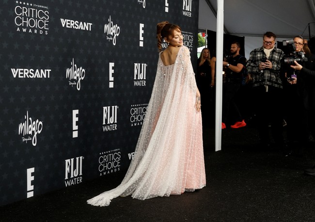 Siluet gaun yang longgar dengan potongan empire memberi efek flowy yang anggun, sementara lapisan tulle transparan bertabur detail bordir floral kecil, memancarkan kesan fantasi modern. Foto: REUTERS/Caroline Brehman