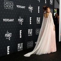 Siluet gaun yang longgar dengan potongan empire memberi efek flowy yang anggun, sementara lapisan tulle transparan bertabur detail bordir floral kecil, memancarkan kesan fantasi modern. Foto: REUTERS/Caroline Brehman