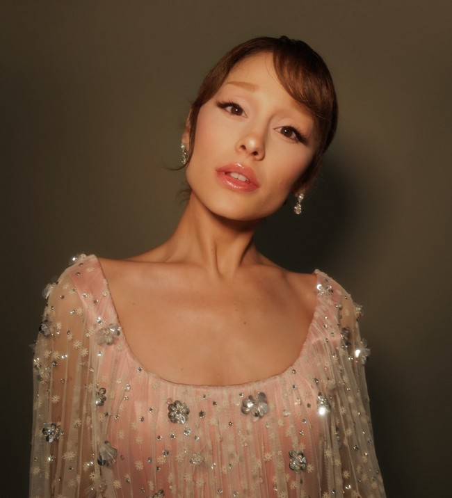 Riasan wajah dan gaya rambut bernuansa pink nude, dengan updo rapi dan poni lembut, mempercantik wajahnya yang mungil dan feminin. Foto: Instagram/@arianagrande