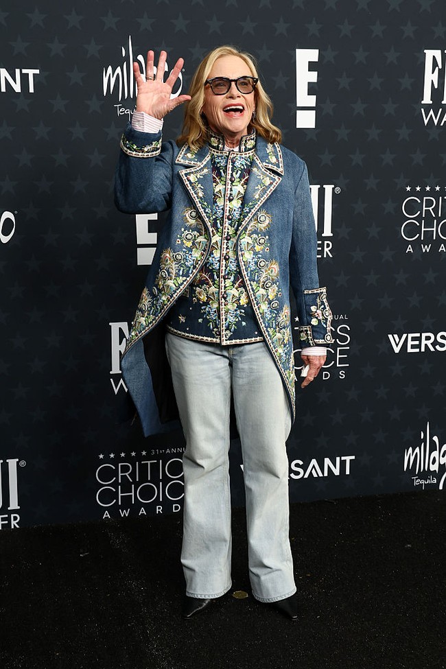 Amy Madigan  tampil unik dengan frock coat chambray biru dari koleksi Dior Men rancangan Jonathan Anderson. Untuk look karpet merah, ia justru memadukannya dengan jeans straight. Klasik, artsy, dan tak terduga. (Foto: Getty Images)