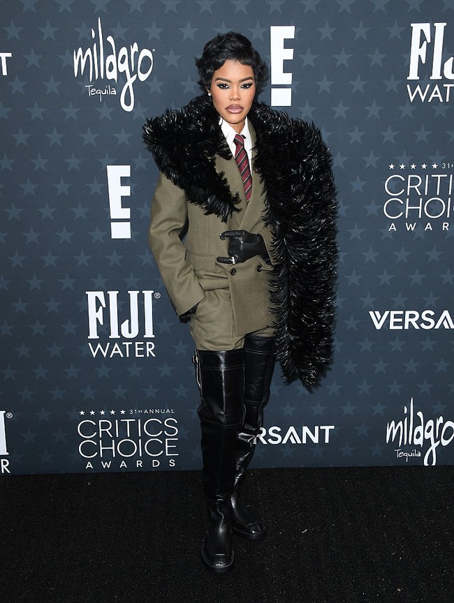 Alih-alih gaun, Teyana Taylor bersolek dengan setelan sharp Saint Laurent karya  Anthony Vaccarello.  Gayanya penuh statement ini terdiri dari jas coklat tegas dipadu boa bulu dramatis, sarung tangan kulit, dan sepatu boots over-the-knee, berikut perhiasan Tiffany & co. yang memberi sentuhan glamor. Powerful dan berkarakter. (Foto: Getty Images)